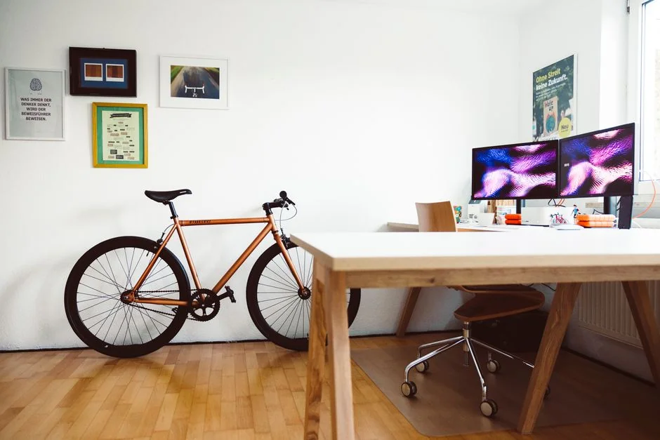 A vibrant workspace featuring a laptop, tablet, and TV with colorful lighting.